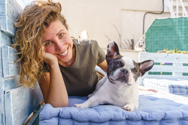 Portrait of woman relax with bulldog at home. Horizontal view of woman playing with pet outdoors