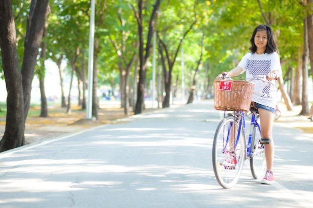 Portrait of woman riding bicycle on road against trees