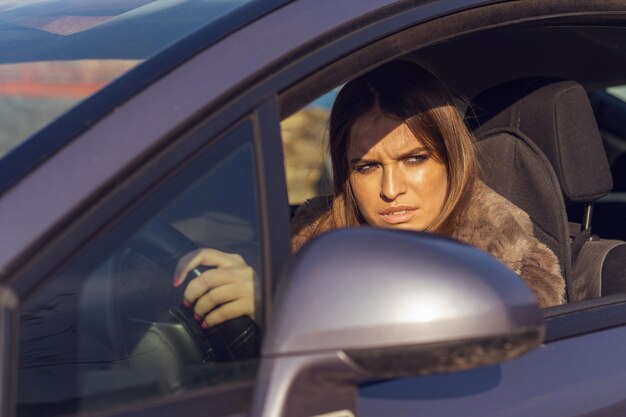 Photo portrait of woman seen through car window