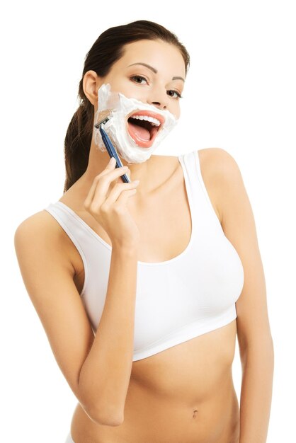 Portrait of woman shaving against white background