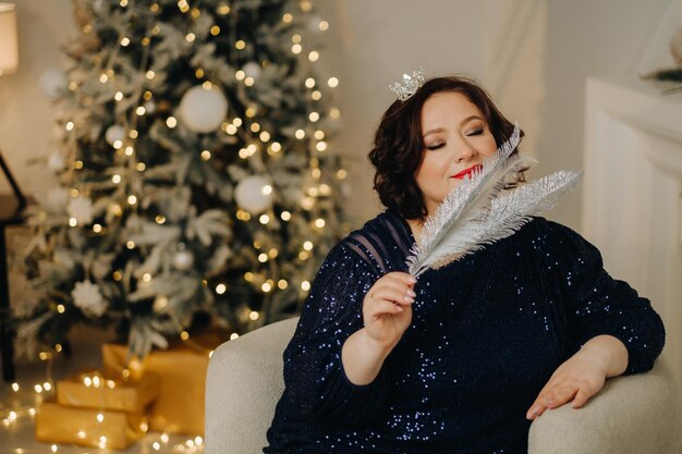 Portrait of a woman in a shiny blue dress in a new year\'s\
interior concept merry christmas and happy new year