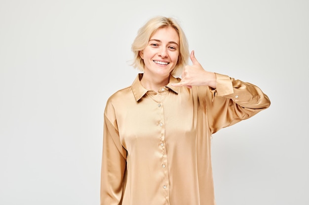 Portrait woman showing call me gesture with fingers isolated on white background