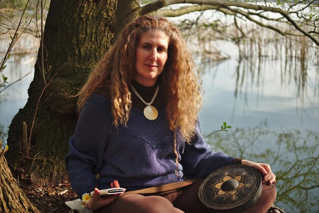 Foto ritratto di una donna seduta contro il lago