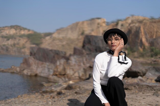 Portrait of woman sitting against rock formation