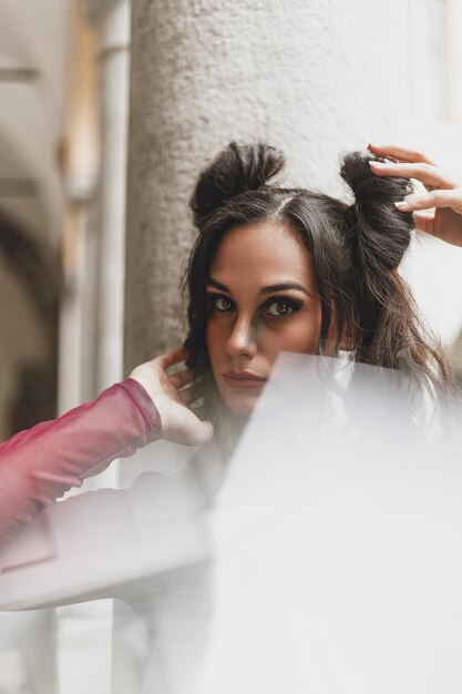 Portrait of woman sitting by wall outdoors