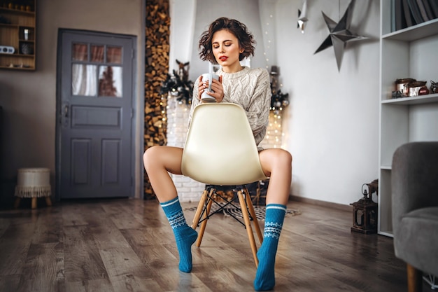 portrait woman sitting on the chair near Christmas tree