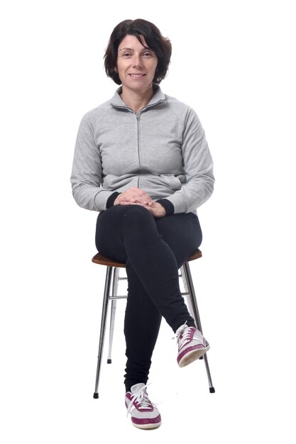 Portrait of a woman sitting on a chair in white background,legs crossed