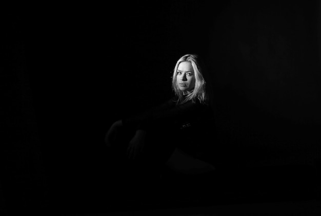 Photo portrait of woman sitting in darkroom