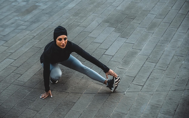 Photo portrait of woman sitting on footpath