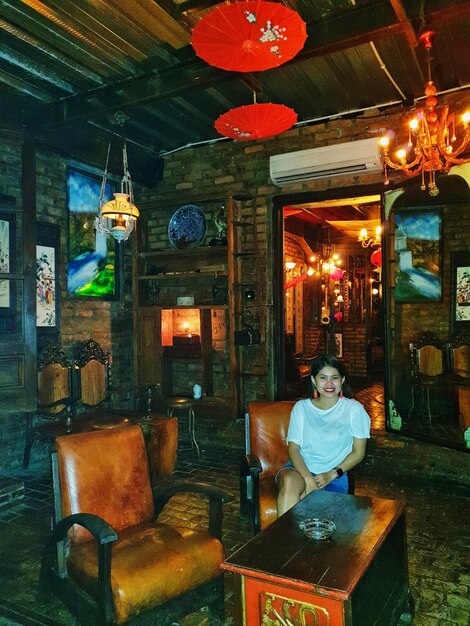 Photo portrait of woman sitting at illuminated restaurant