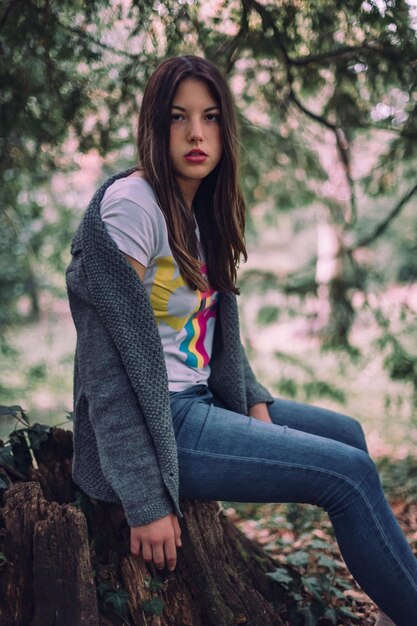 Portrait of woman sitting in park during autumn