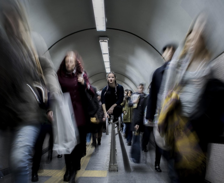 Photo portrait of woman sitting on railing at subway station