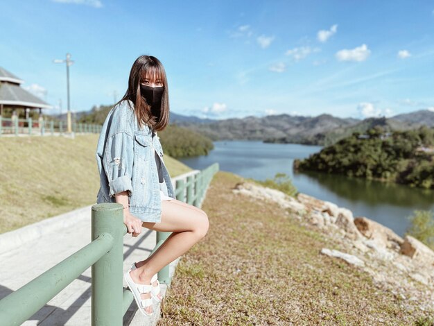 Portrait of woman sitting on railing