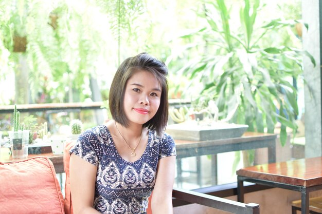 Portrait of woman sitting on seat at cafe