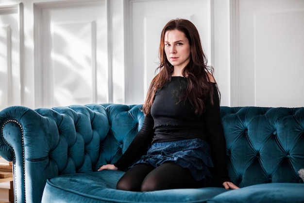 Photo portrait of woman sitting on sofa at home