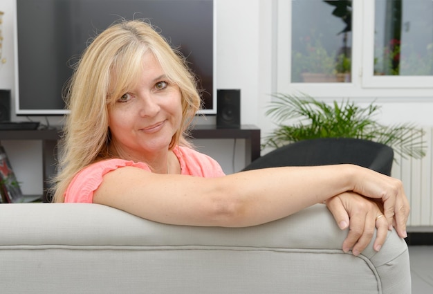 Photo portrait of woman sitting on sofa at home