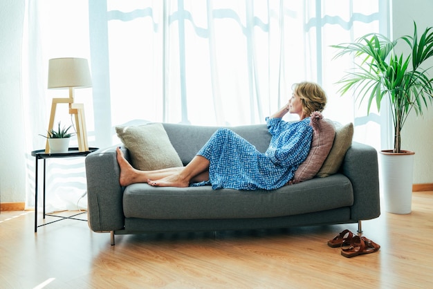 Portrait of woman sitting on sofa at home