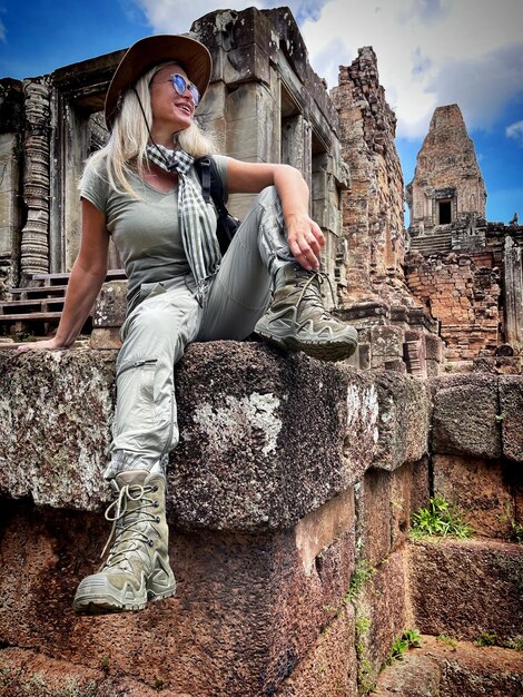 Portrait of woman sitting on stone wall