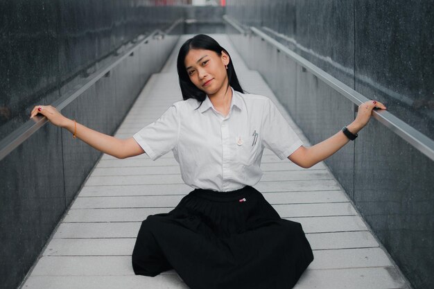 Photo portrait of woman sitting on walkway