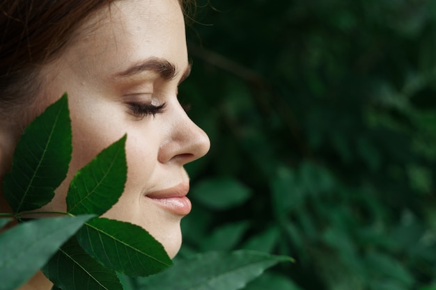 Photo portrait of a woman skin care bare shoulders green leaves nature closeup