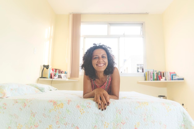 Foto ritratto di una donna che sorride e guarda la telecamera dall'interno della sua casa