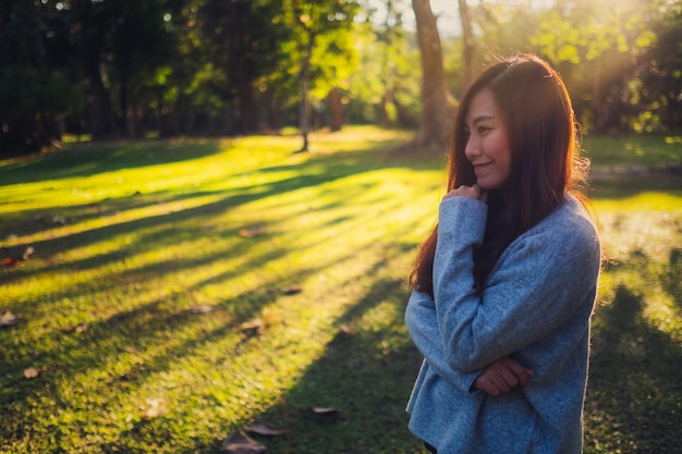 Portrait of woman smiling while standing at park