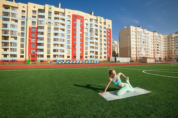 portrait woman at stadium doing yoga