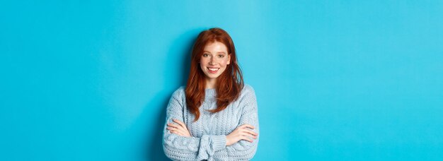 Portrait of woman standing against blue background