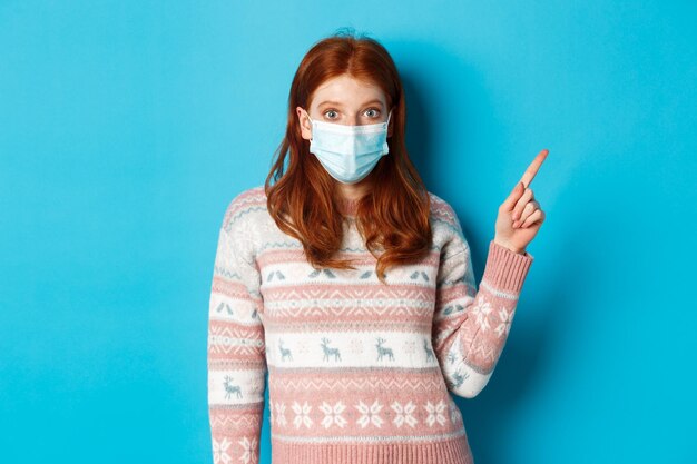 Portrait of woman standing against blue background