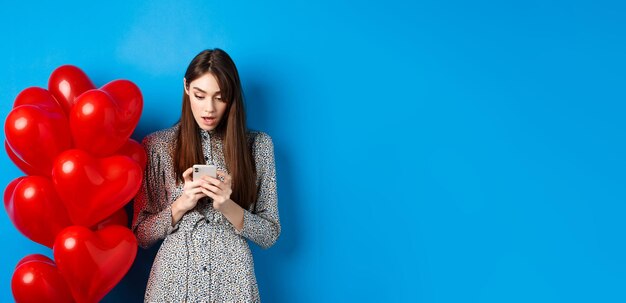 Portrait of woman standing against blue background