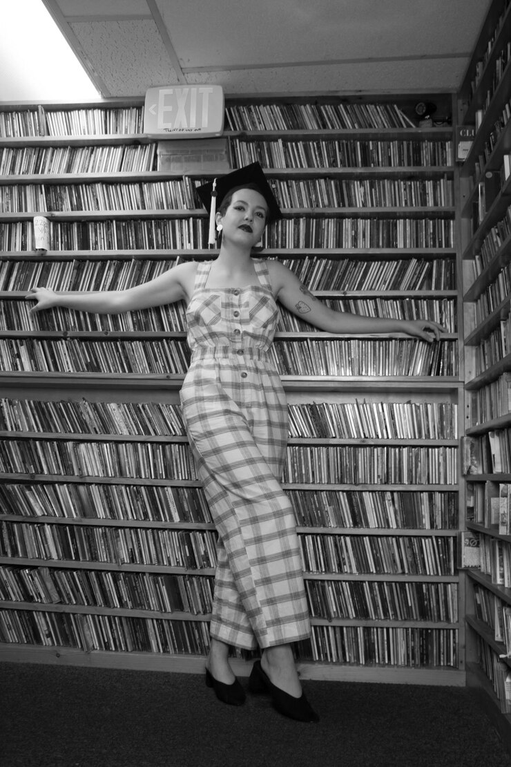 Фотография портрет женщины, стоящей на книжной полке