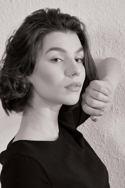 Photo portrait of woman standing against gray wall