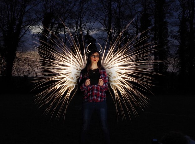 Photo portrait of woman standing against light painting