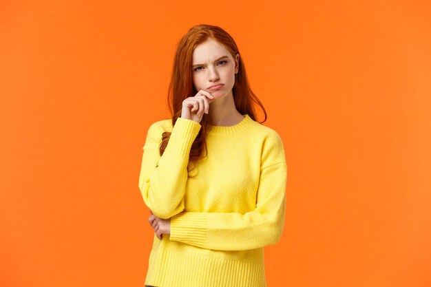 Portrait of woman standing against orange background