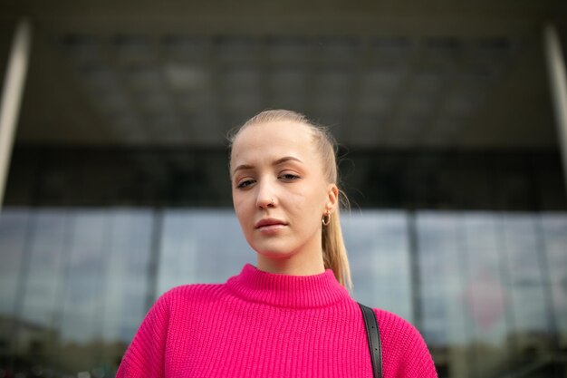 Foto ritratto di una donna in piedi su uno sfondo rosa