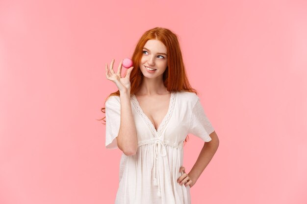 Portrait of woman standing against pink background