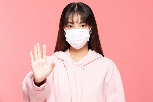 Portrait of woman standing against pink background