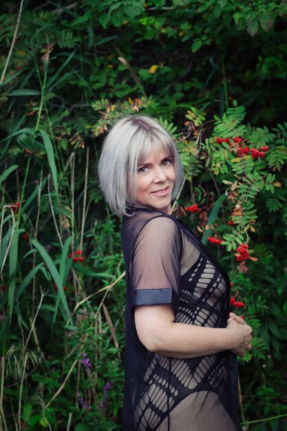 Portrait of woman standing against plants