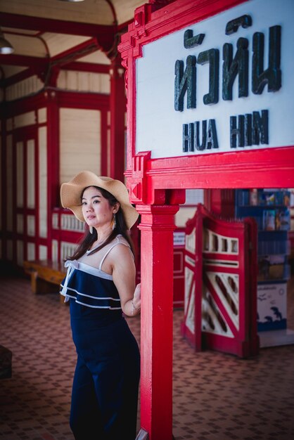 Portrait of woman standing against red wall