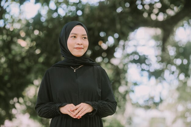 Photo portrait of woman standing against tree