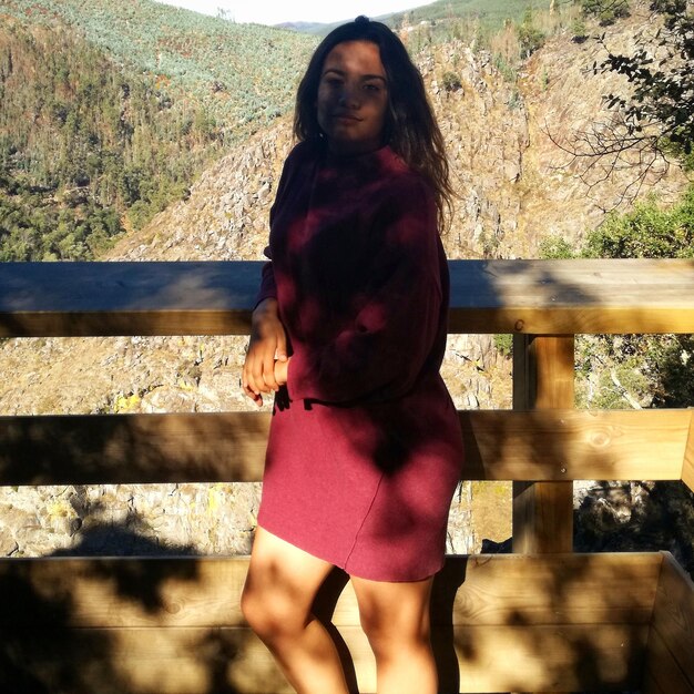 Portrait of woman standing against tree