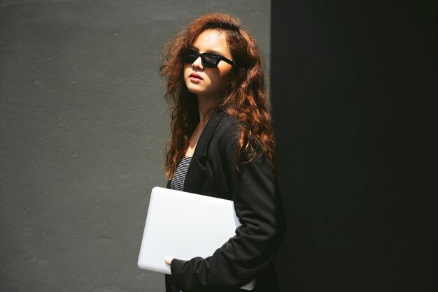 Portrait of woman standing against wall