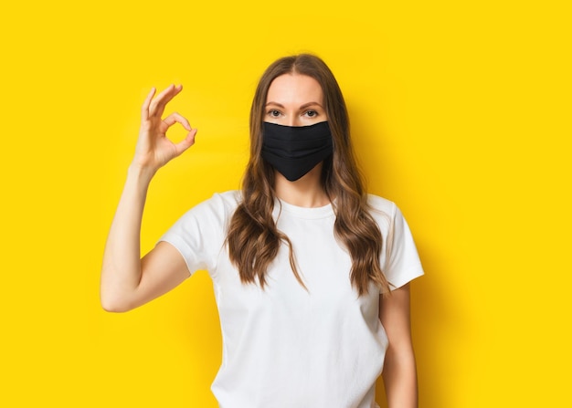 Portrait of woman standing against yellow background