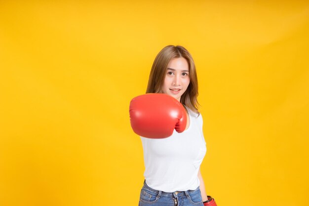 Portrait of woman standing against yellow background