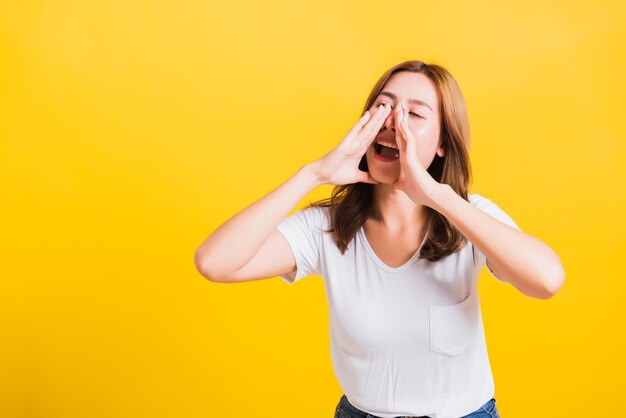 Portrait of woman standing against yellow wall