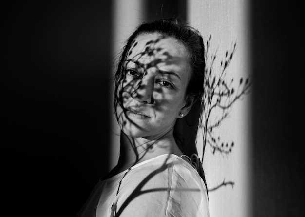 portrait woman standing by wall at home