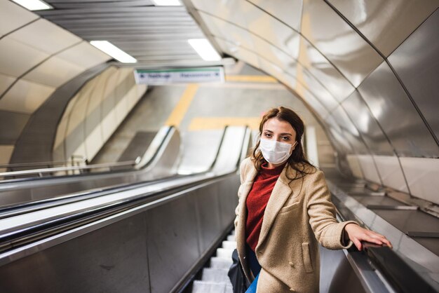 Portrait of woman standing on escalator at subway station
