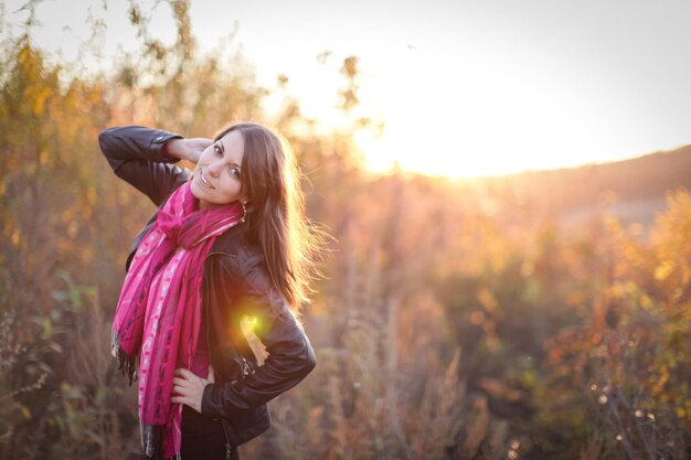 Photo portrait of woman standing on field against sky during sunset