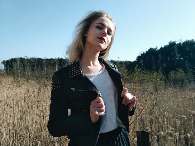 Photo portrait woman standing on field against sky