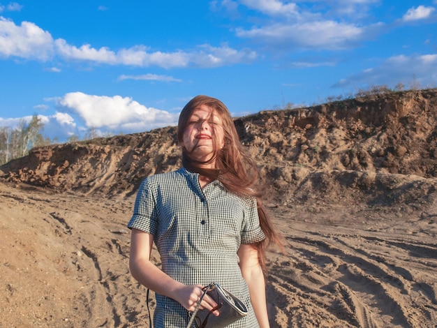 Photo portrait of woman standing on sand against sky